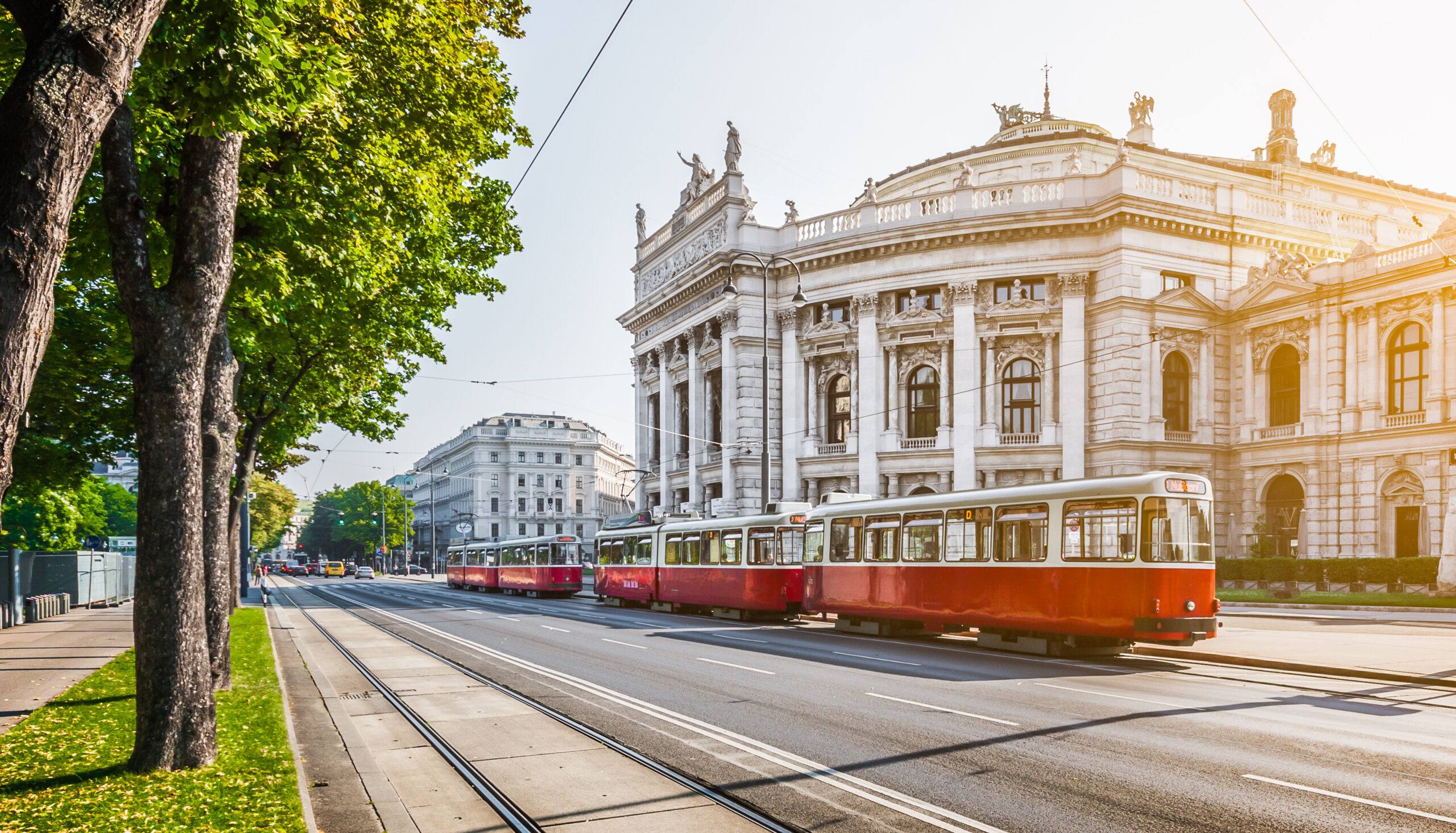 Street view with red traditional tram and historical buildings in the background.